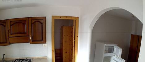 A kitchen with wooden cabinets, a stove, and a refrigerator.