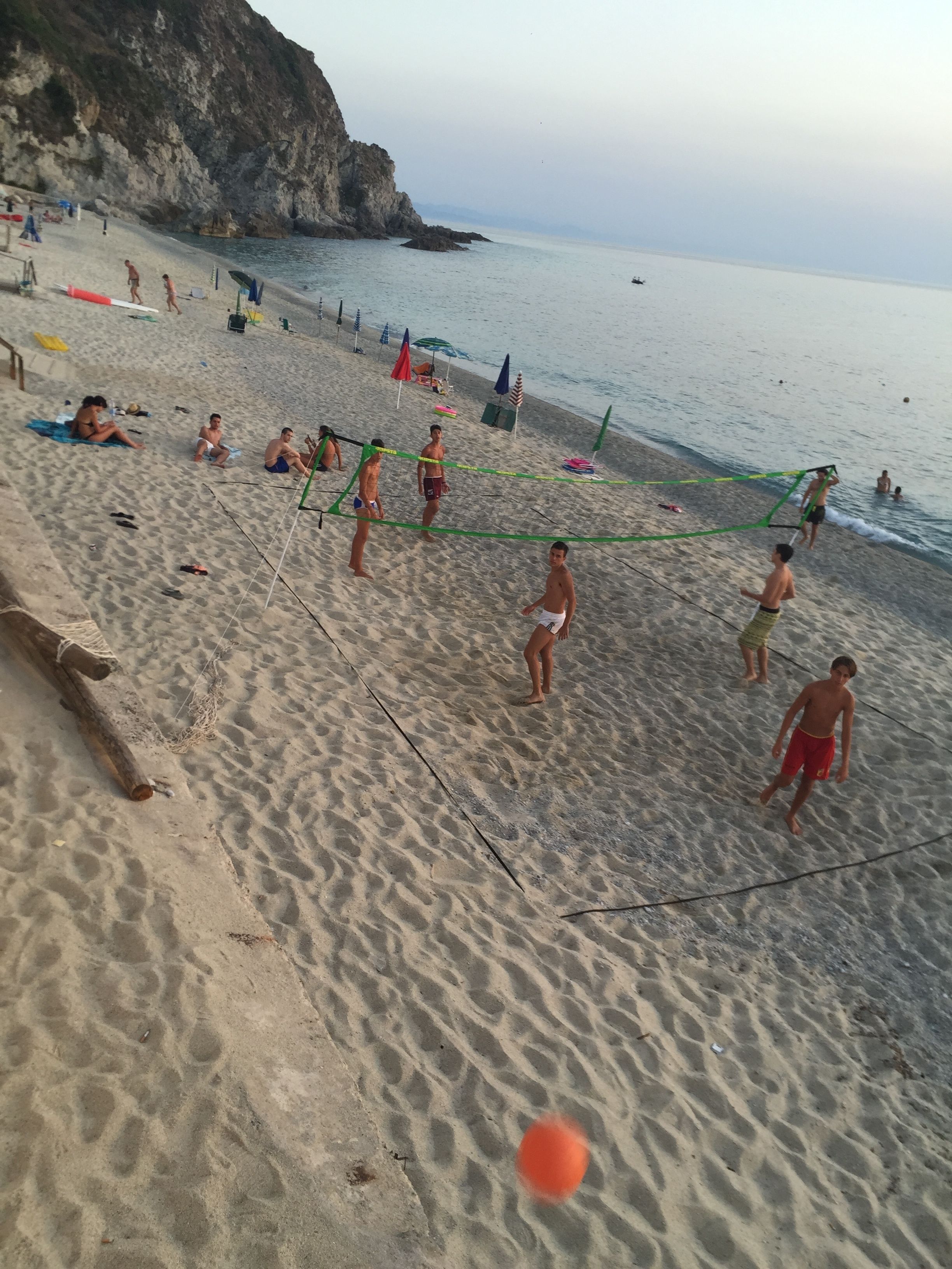 Un match de volleyball de plage avec des joueurs et des spectateurs.