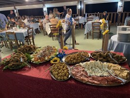 Un bufé con diversos alimentos, incluyendo carnes, quesos y verduras.