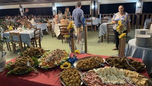 A buffet with various food items and a dining area with tables and chairs.