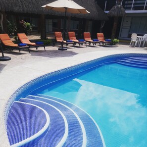 室外游泳池，提供泳池遮陽傘和日光浴躺椅