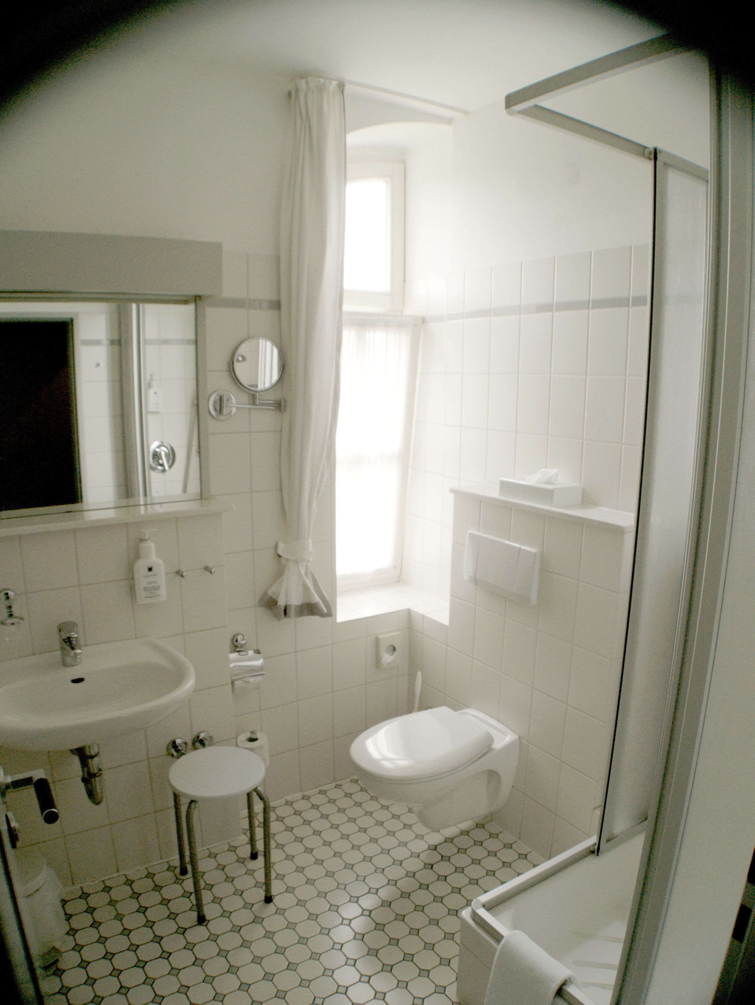 A bathroom with a sink, toilet, and shower.