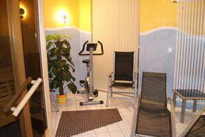 Exercise in style with a compact fitness area featuring an exercise bike and a comfortable chair.