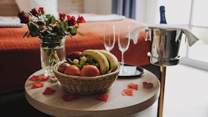 A breakfast setting with a fruit bowl, wine glasses, and a vase of flowers on a wooden table. - Hotel Landhaus Schieder (Schieder-Schwalenberg)