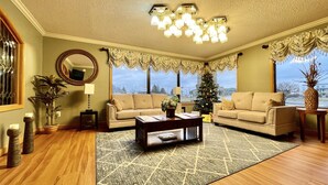 A living room with a beige sofa, a coffee table, and a Christmas tree. - FairBridge Inn & Suites Fort Wayne (Fort Wayne)