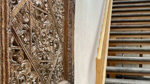 A wooden carved frame with intricate designs, a marble-like countertop, and a staircase with wooden steps. - FairBridge Inn & Suites Fort Wayne (Fort Wayne)