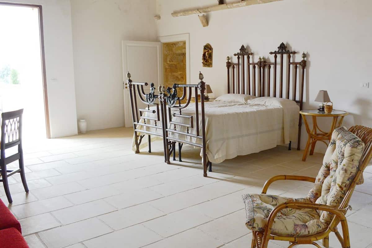 Une chambre à coucher comprenant un lit, une chaise, une table de chevet et une armoire.