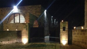 Ein Steinhaus mit Rundbogenfenstern und einem Eingangstor in der Nacht.