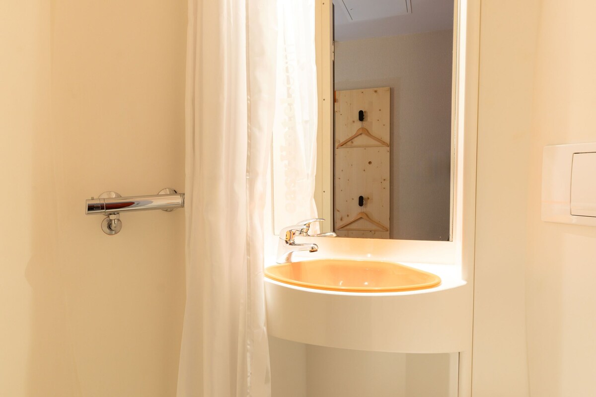 A bathroom with a shower, a sink, and a toilet.