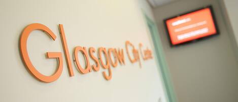 A sign with the text "Glasgow City Centre" on a wall.