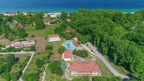 Vista aérea de un resort con piscina, edificios de hotel y playa.
