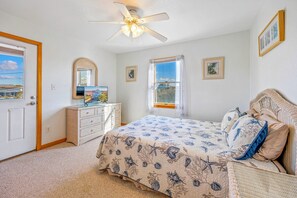 A bedroom with a bed, dresser, ceiling fan, and a window with curtains. - Oceanview Home with Private Pool, Hot Tub, Game Room, and Screened Porch (Salvo)