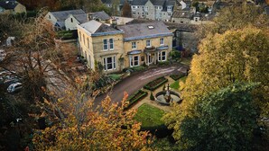 A large stone building with multiple windows and a central courtyard with a fountain. - Manor House Lindley (Huddersfield)