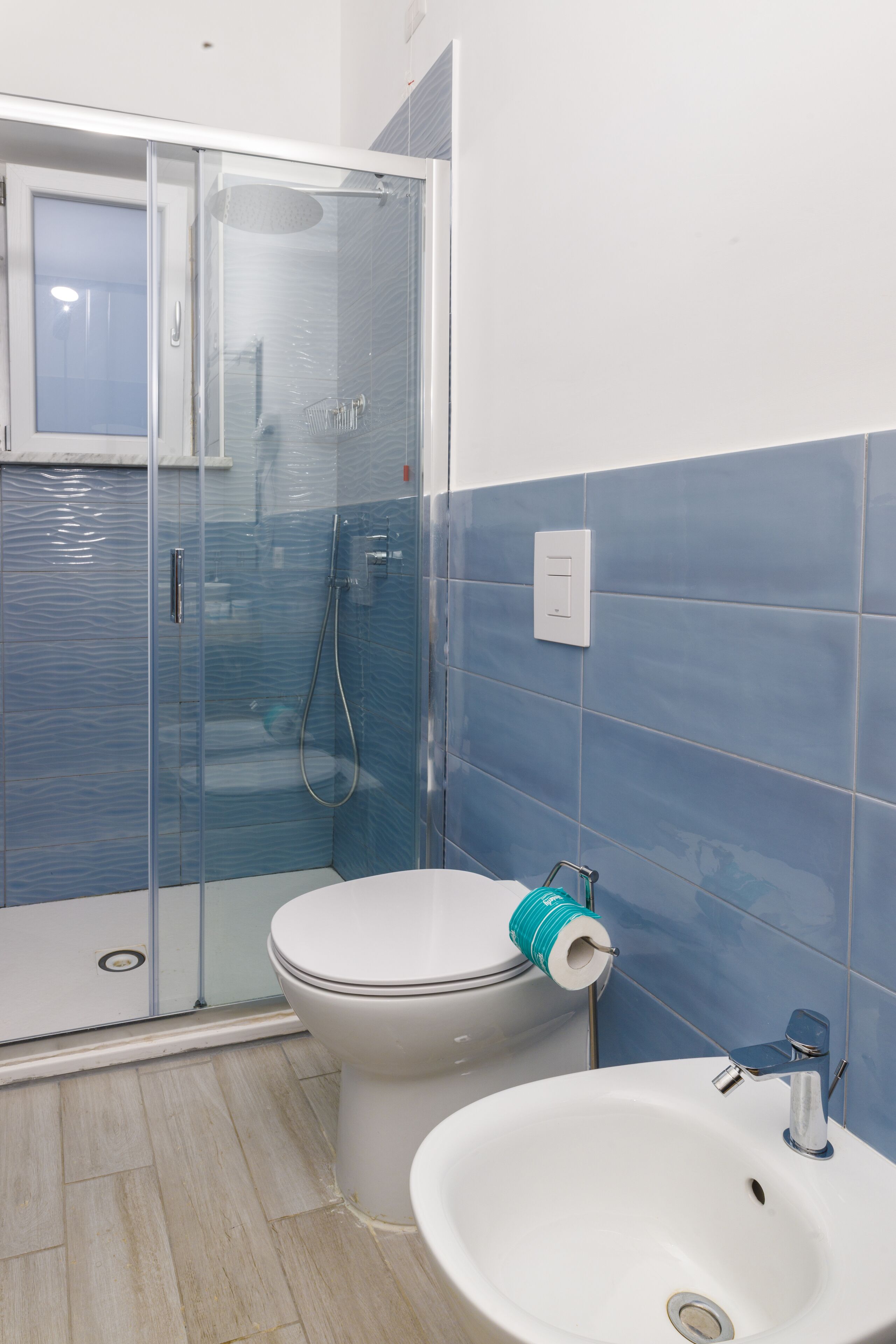 Een badkamer met een douchecabine, toilet en wastafel.