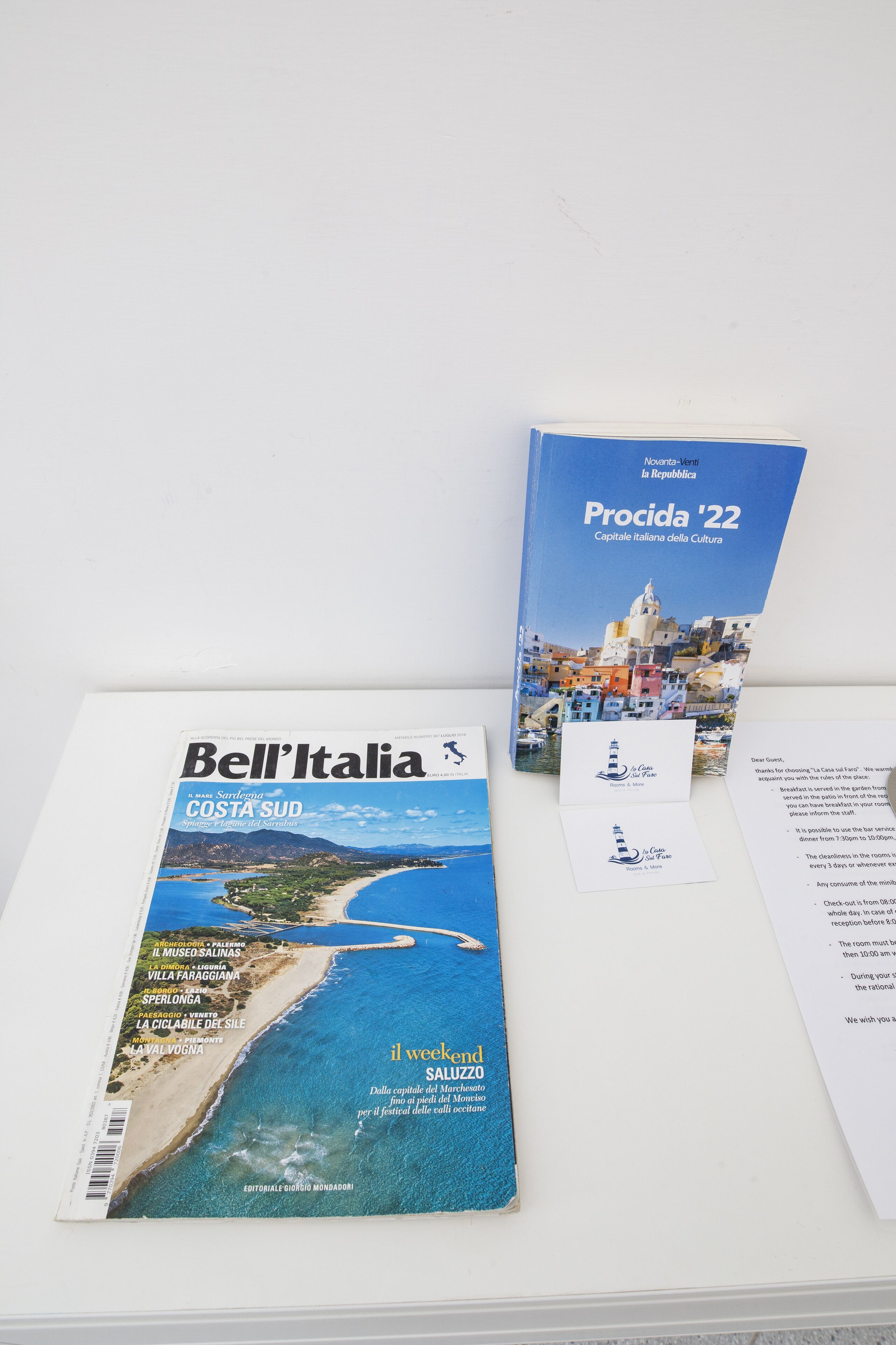 A Bell'Italia magazine cover with a coastal scene and text about Costa SUD.
