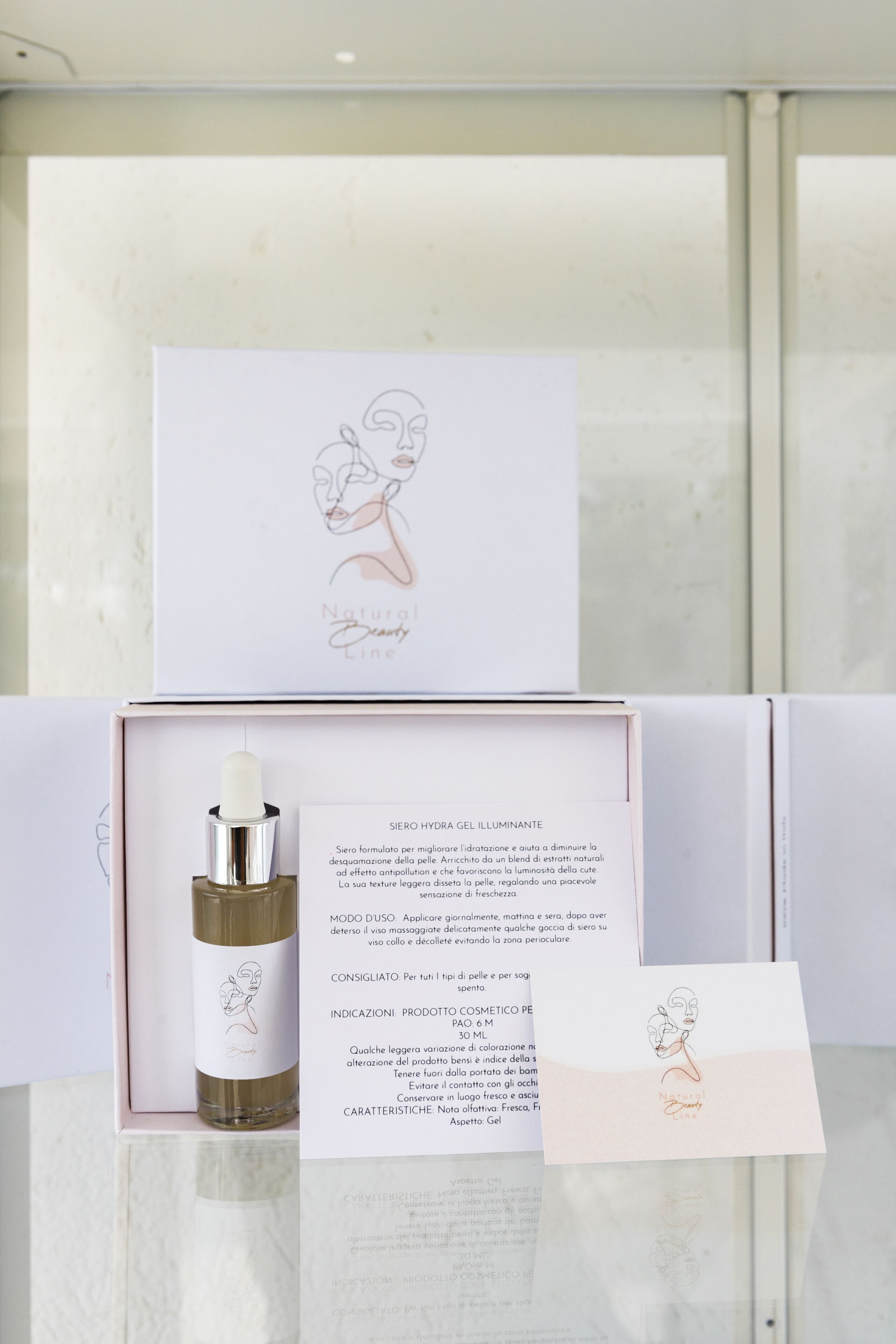 Eine Produktbox mit einer Flasche und einer Karte, mit einer Zeichnung einer Frau und Text auf Italienisch.