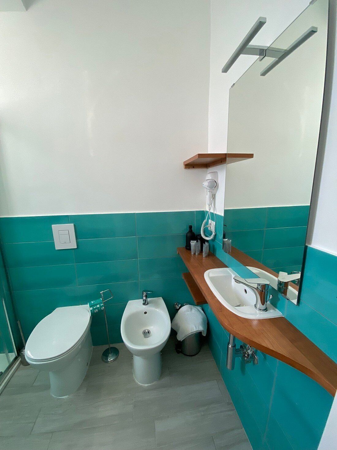 Un baño con inodoro, bidé y lavamanos.