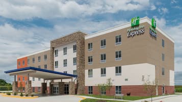 A Holiday Inn Express hotel with a modern design, featuring a covered entrance and a landscaped front yard.