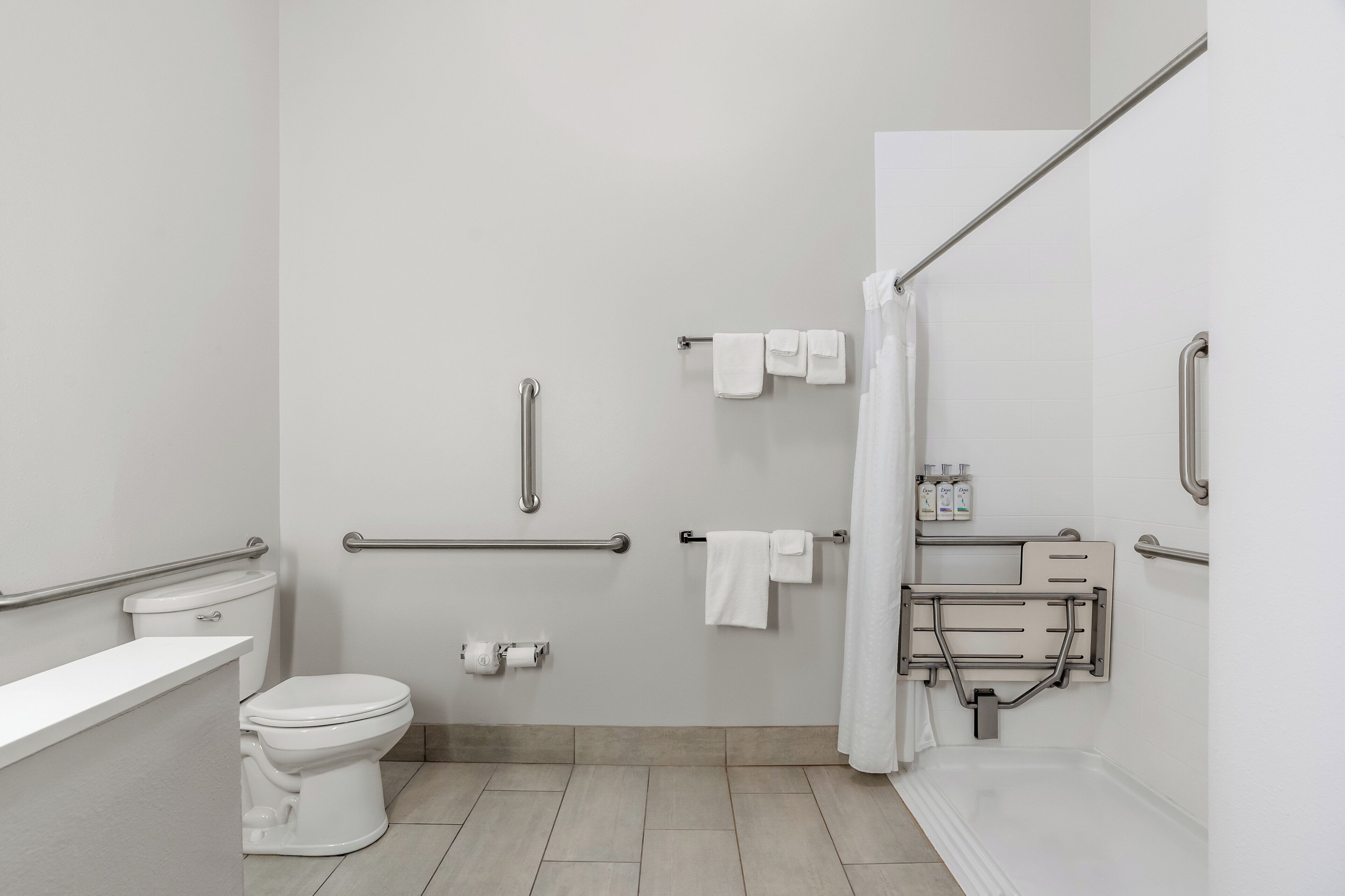 A modern bathroom with a toilet, bidet, and shower area.