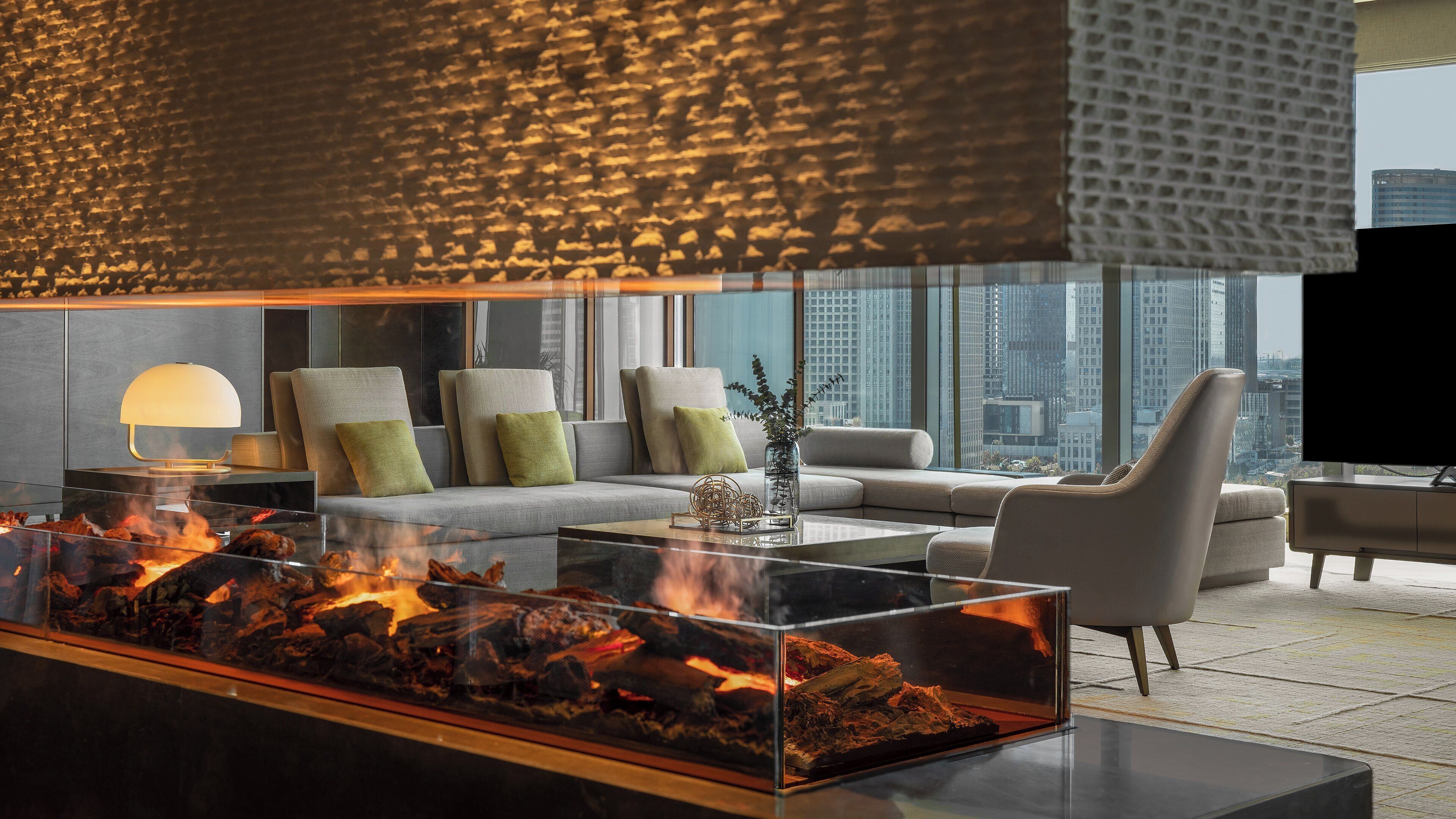 A modern living room with a glass-top fireplace, a sofa set, and a television.