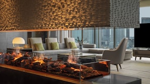 A modern living room with a glass-top fireplace, a sofa set, and a television. - InterContinental Tianjin Yujiapu Hotel & Residences by IHG (Tianjin)