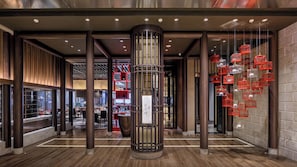 A modern interior with a central column, wooden flooring, and red birdcage decorations. - InterContinental Tianjin Yujiapu Hotel & Residences by IHG (Tianjin)