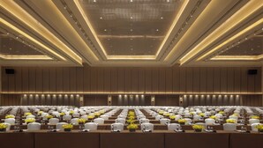 A conference room with rows of tables, chairs, and floral centerpieces. - InterContinental Tianjin Yujiapu Hotel & Residences by IHG (Tianjin)