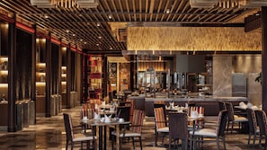 A modern restaurant with a bar area, seating arrangements, and a decorative ceiling.