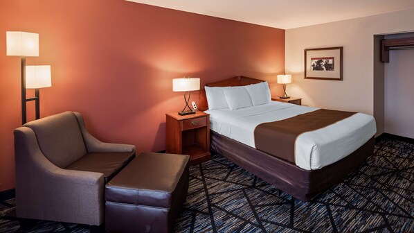 A hotel room with a bed, two bedside tables with lamps, a chair, and a small table.
