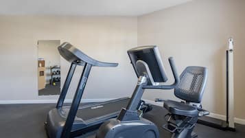 A gym with a treadmill and an elliptical machine.