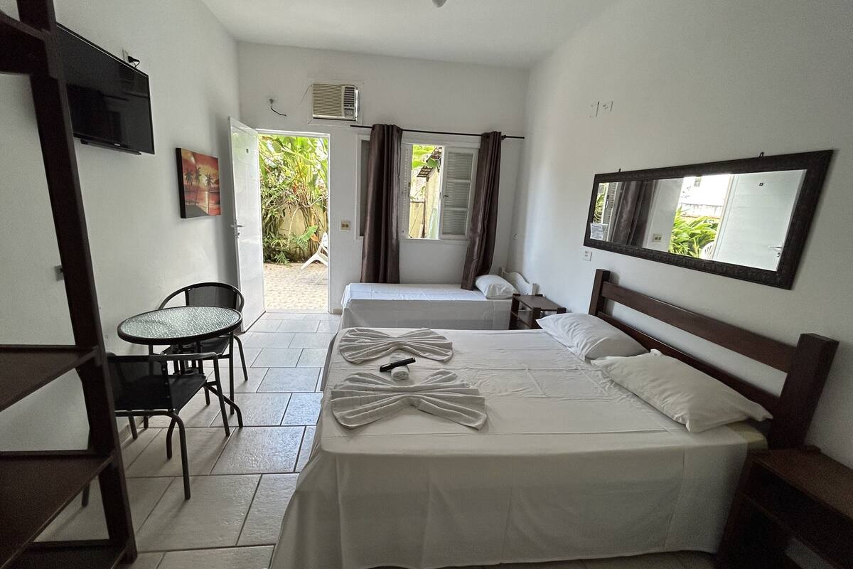 Ein Hotelzimmer mit einem Bett, einem Sessel, einem kleinen Tisch und einem Fernseher.