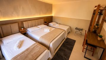 A hotel room with two beds, a desk, and a chair.