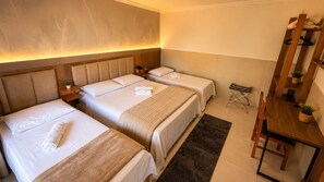 A hotel room with two beds, a desk, and a chair. - Hotel Casa Encantada Penedo (Itatiaia)