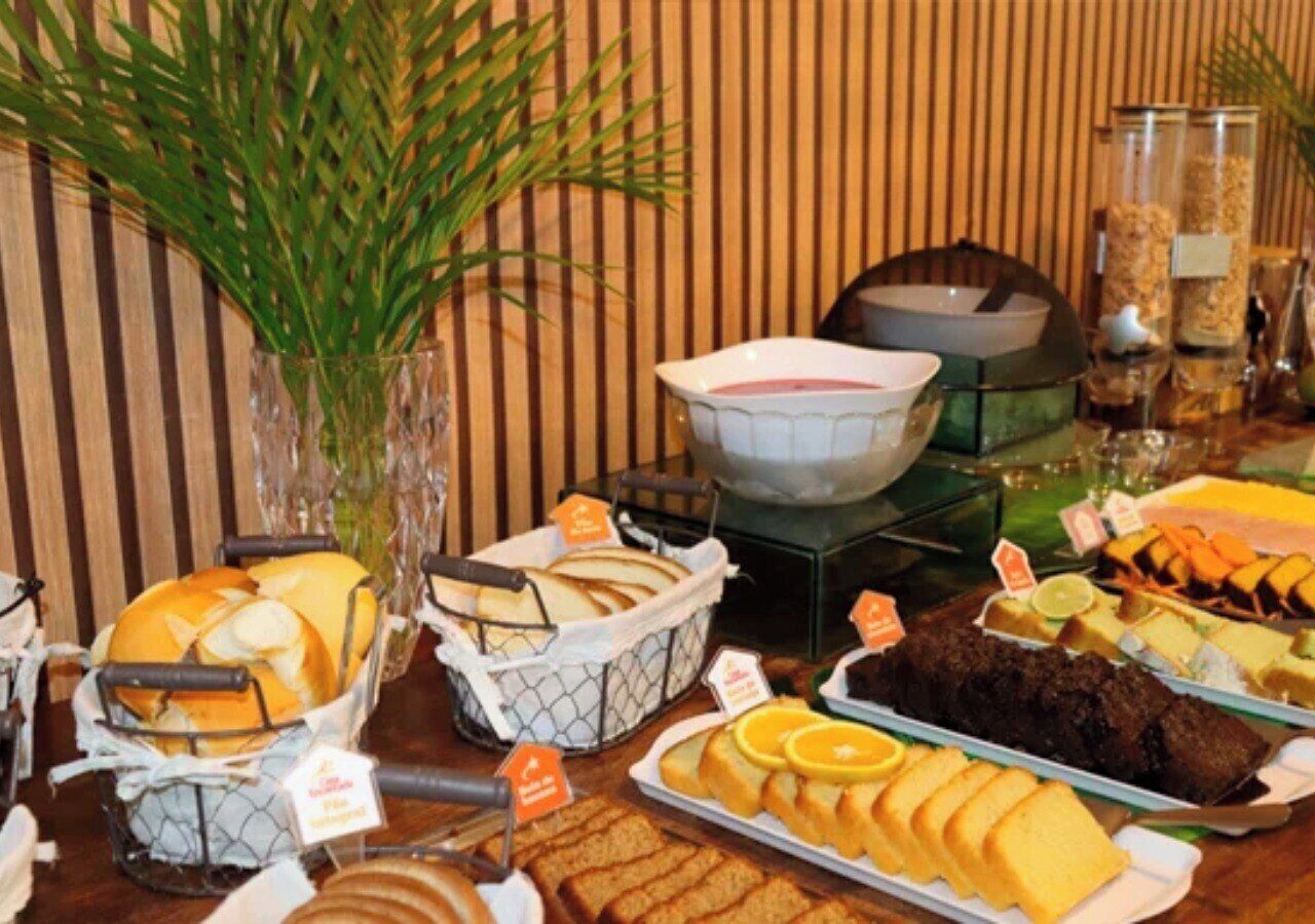 A buffet table with various food items including bread, pastries, and desserts.