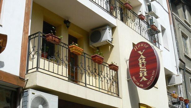 Un edificio con varios balcones, unidades de aire acondicionado y un cartel que indica 'Varushka BAPVVIIA Rooms'.