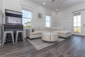 Relax in this spacious living room with a sofa, coffee table, and bar area, offering a view of the outdoors.