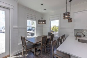 Enjoy meals in the kitchen and dining area with a backsplash and wooden table.