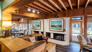 Una sala de estar acogedora con chimenea, vigas de madera y asientos cómodos.