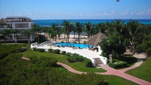 Ein Resort mit Pool, Palmen und Meerblick.