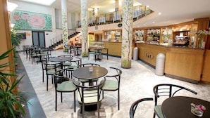 A spacious indoor area with multiple dining tables and chairs, a bar area, and a staircase leading to an upper level. - Hotel Eurotel (Grottammare)
