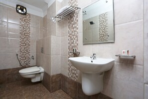 A modern bathroom with a toilet, sink, and shower. - OYO 10188 Hotel DS Grand Inn (Ramachandrapuram)