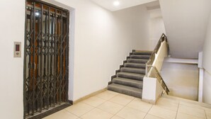 A staircase with a metal railing leading to an upper floor. - OYO 10235 Oyster Transit Hotels (Hyderabad)