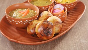 A plate with various dishes including flatbreads and three bowls of different soups. - OYO 9305 Hotel Dwarika Inn (Jabalpur)