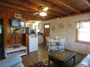 A cozy living room with a foosball table, a TV, and a kitchen in the background. - Summer Special/RIGHT ACROSS from OCEAN/Fenced yard/pet friendly  (Nags Head)
