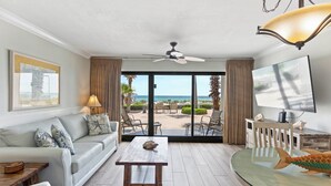 Una sala de estar con sofá, mesa de centro y vista al mar.