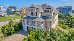 A large, multi-story house with a prominent front porch and a garage. - Semi-Oceanfront Dog Friendly w/ Pool, Hot Tub, Home Theater, and Game Room (Avon)