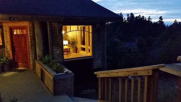 A stone house with a wooden deck and a glass door leading to an interior with a table and chairs. - Need to get away? This is your home away from - everything!
SEAGLASS Irish Beach (Manchester)