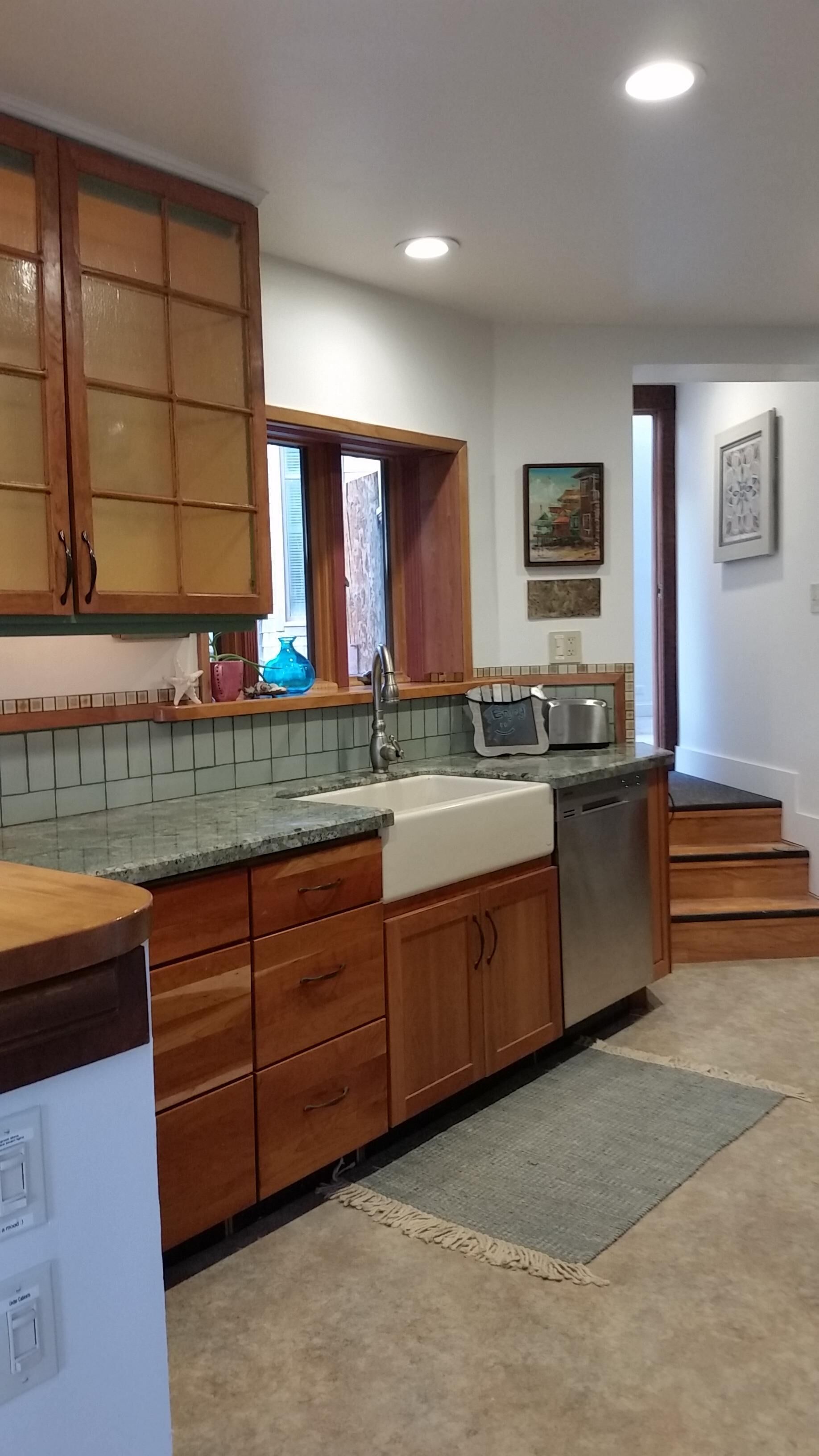 A kitchen with wooden cabinets, a sink, and a countertop.