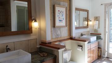 A modern bathroom with two sinks, a large mirror, and a framed fish illustration.