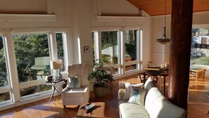 A spacious living room with large windows, a white sofa, a wooden coffee table, and a dining area with a table and chairs. - Need to get away? This is your home away from - everything!
SEAGLASS Irish Beach (Manchester)